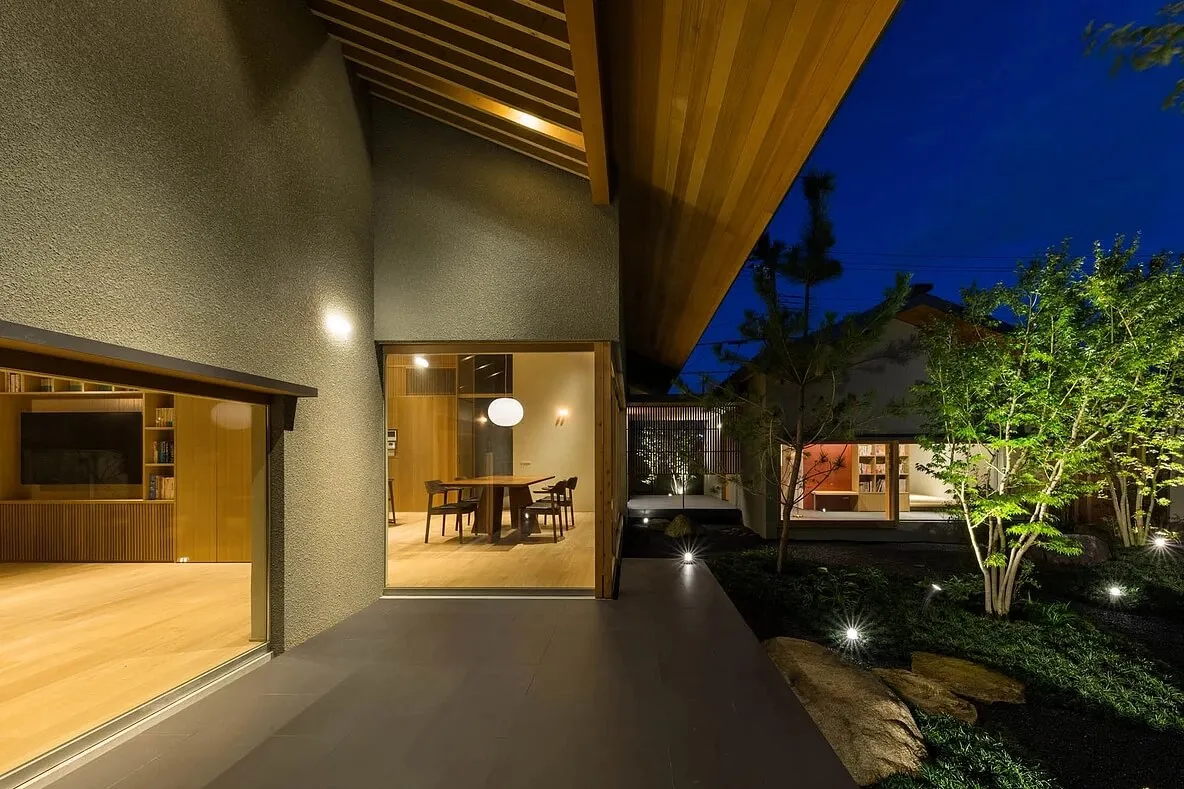 簡約住宅室內,擺放木質餐桌與餐椅,周圍是美麗的戶外景觀。