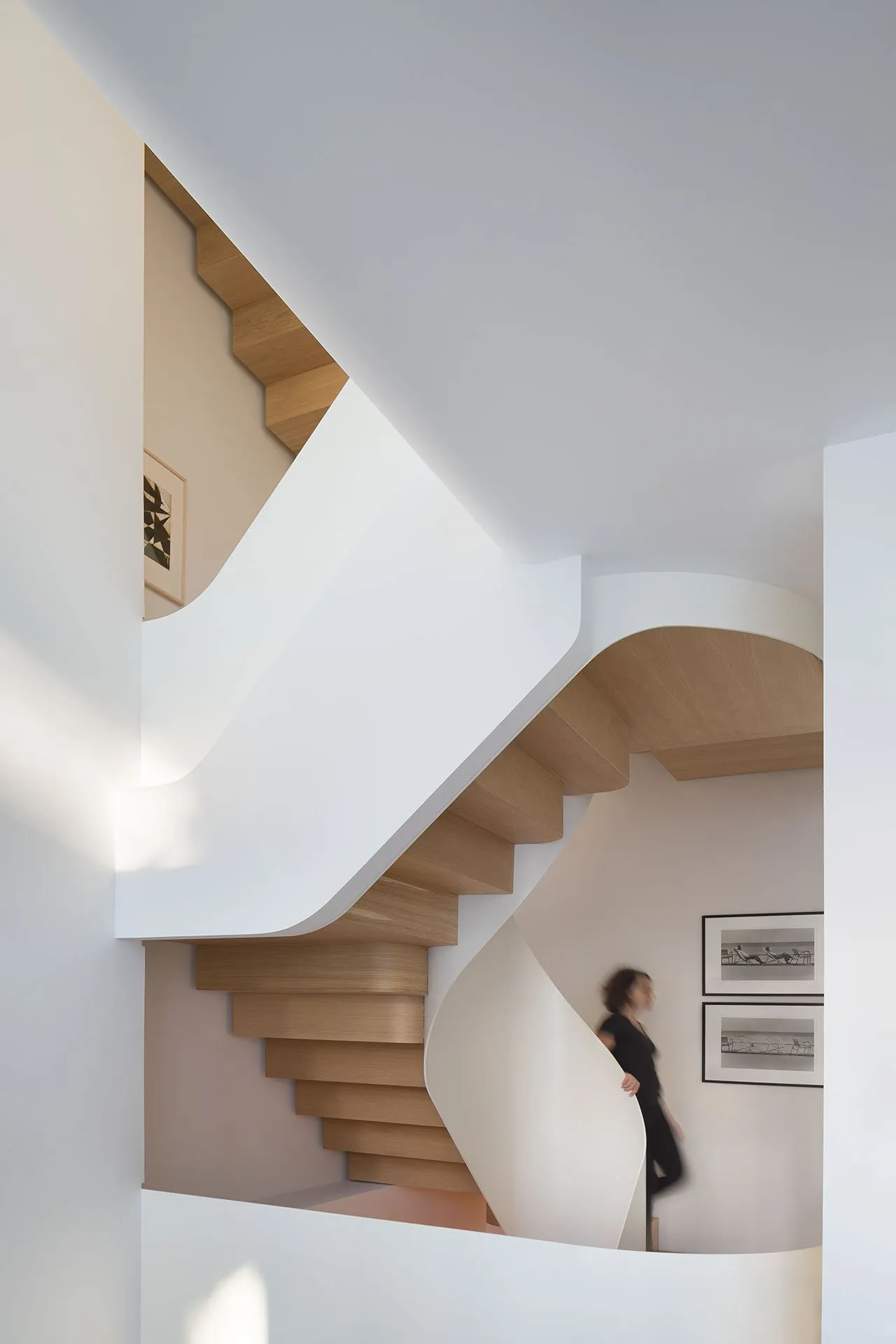 A modern staircase with wooden steps and a white railing.
