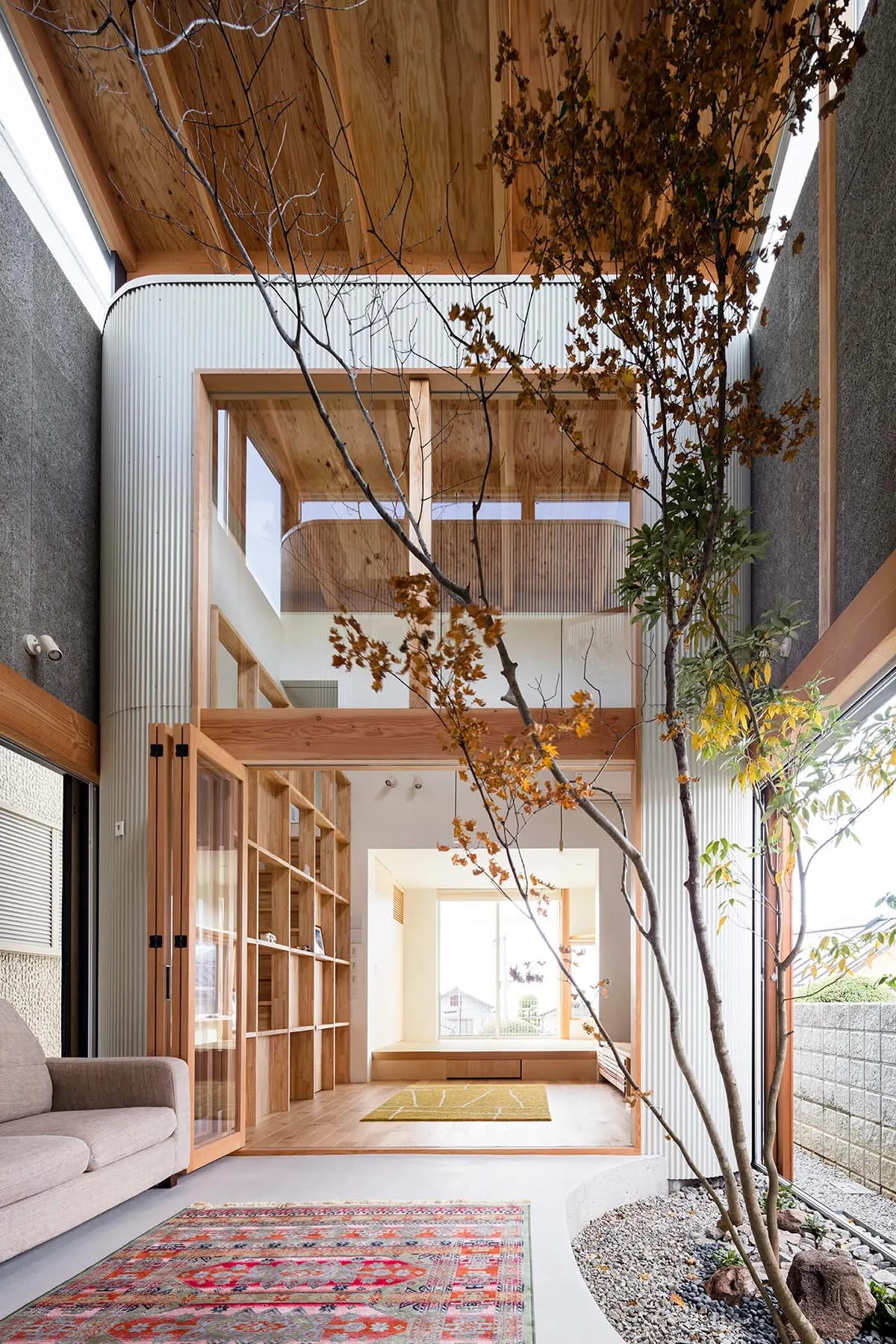 現代客廳中庭採用混凝土牆與波浪金屬屋頂，搭配木質內裝