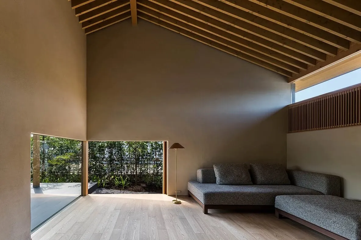 A minimalist living room featuring concrete flooring and wood slat wall.