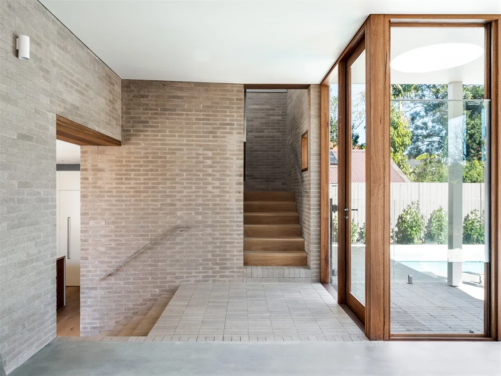 Modern industrial lobby featuring exposed brick walls, concrete flooring, and large glass windows