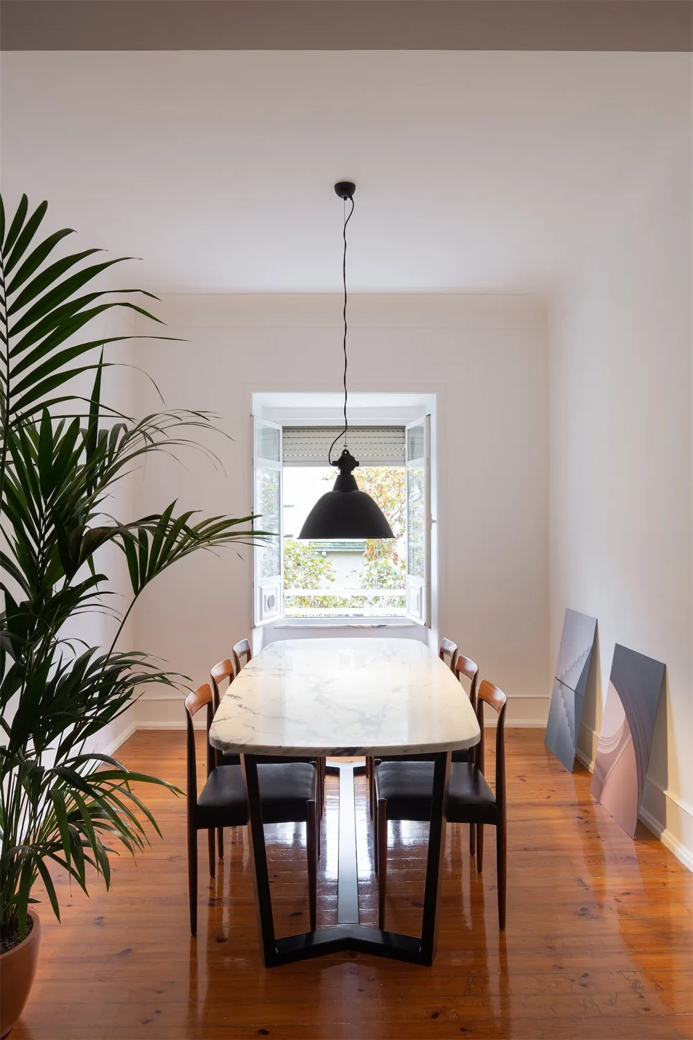 Modern dining room featuring a marble table and black chairs.