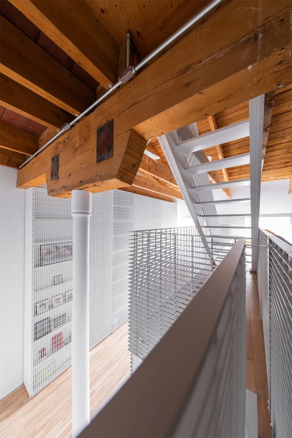 An image showcasing a modern loft interior with wooden beams and metal railings.