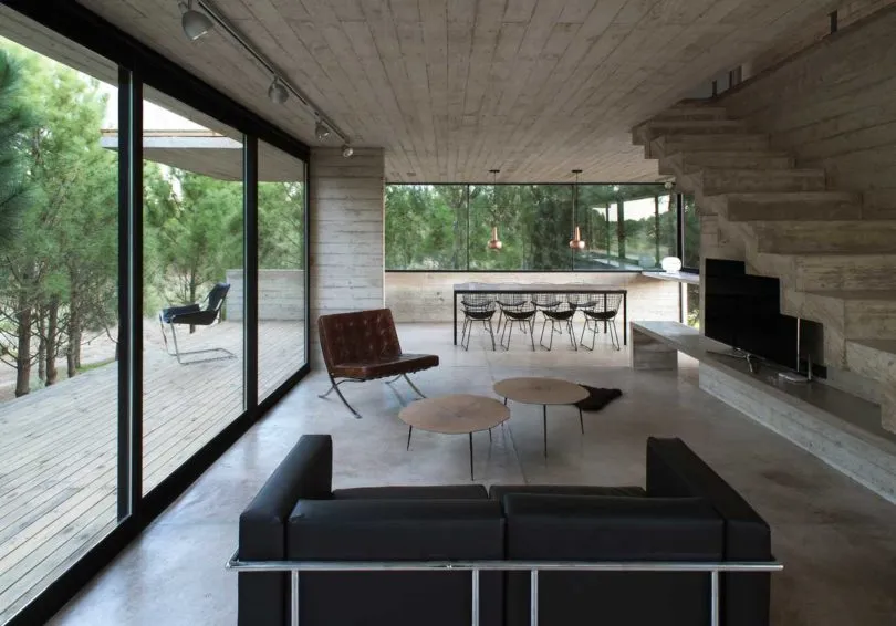 A modern living room with concrete flooring and minimalist furniture.