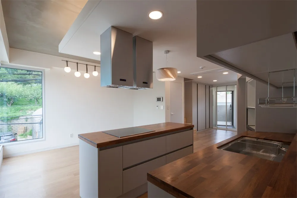 Modern kitchen featuring wood countertops and concrete island.