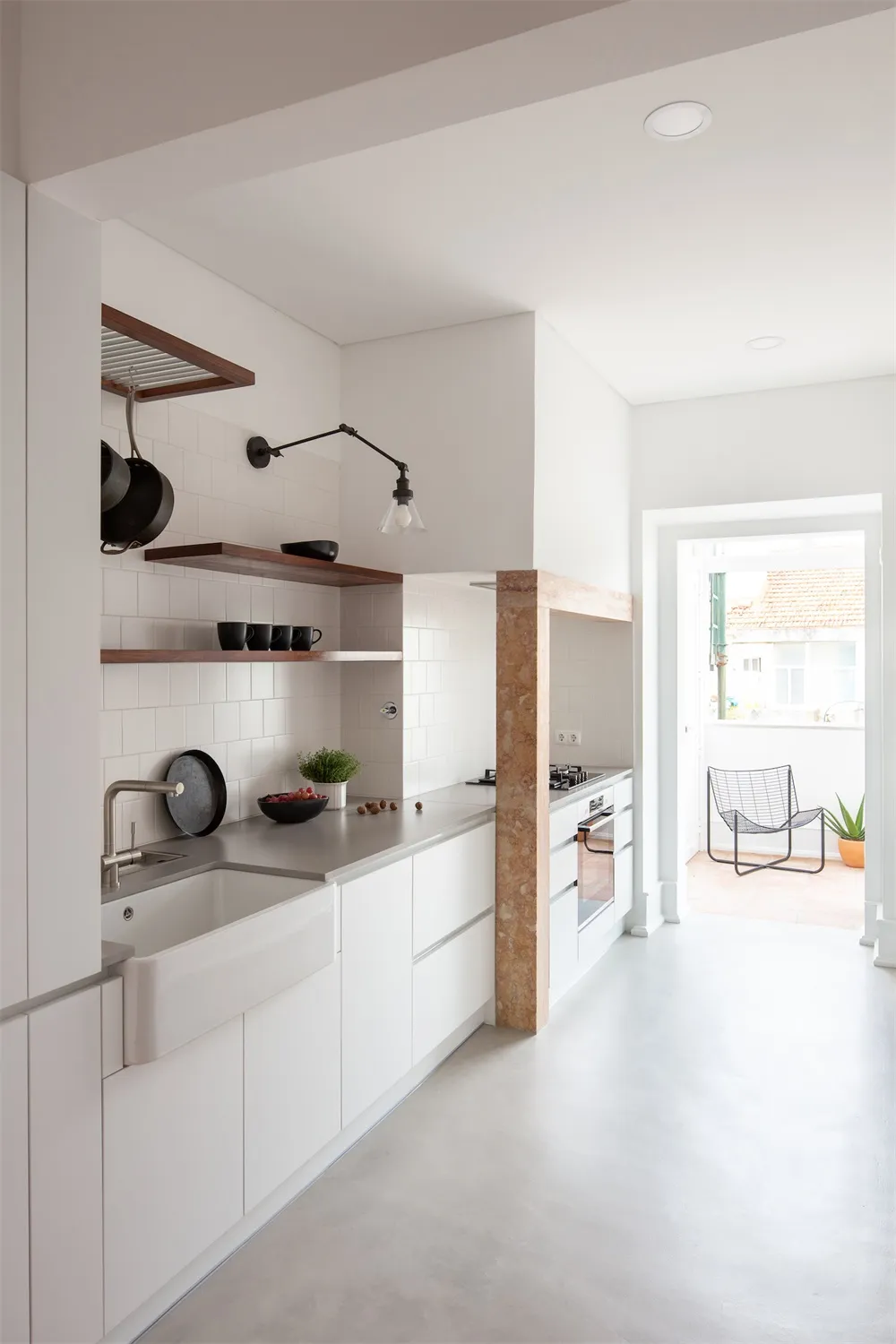 Modern minimalist kitchen with white cabinetry, open shelves, and a sleek countertop.