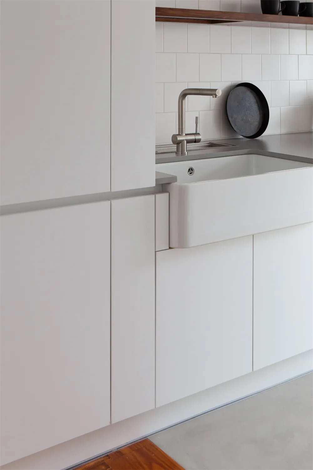 A minimalist kitchen with white cabinetry.
