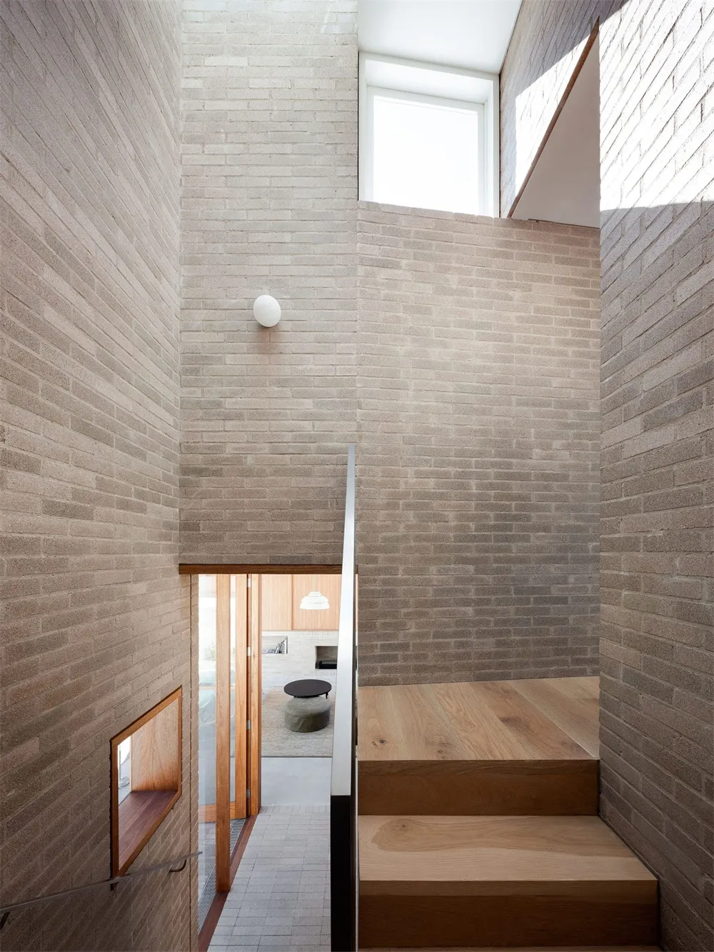 Modern staircase with exposed brick walls and overhead lighting