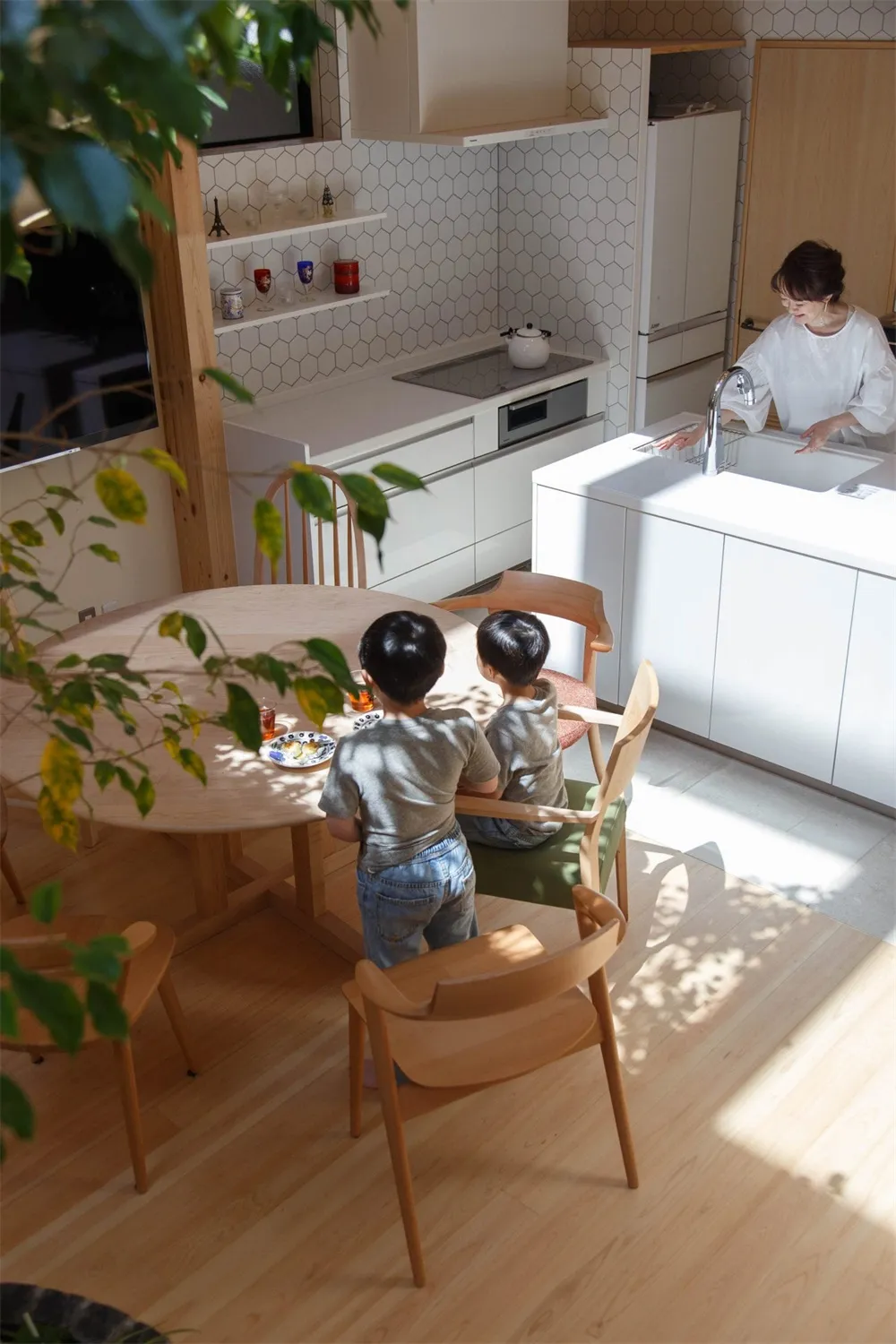 A minimalist residential kitchen featuring ceramic tiles and wooden furniture.