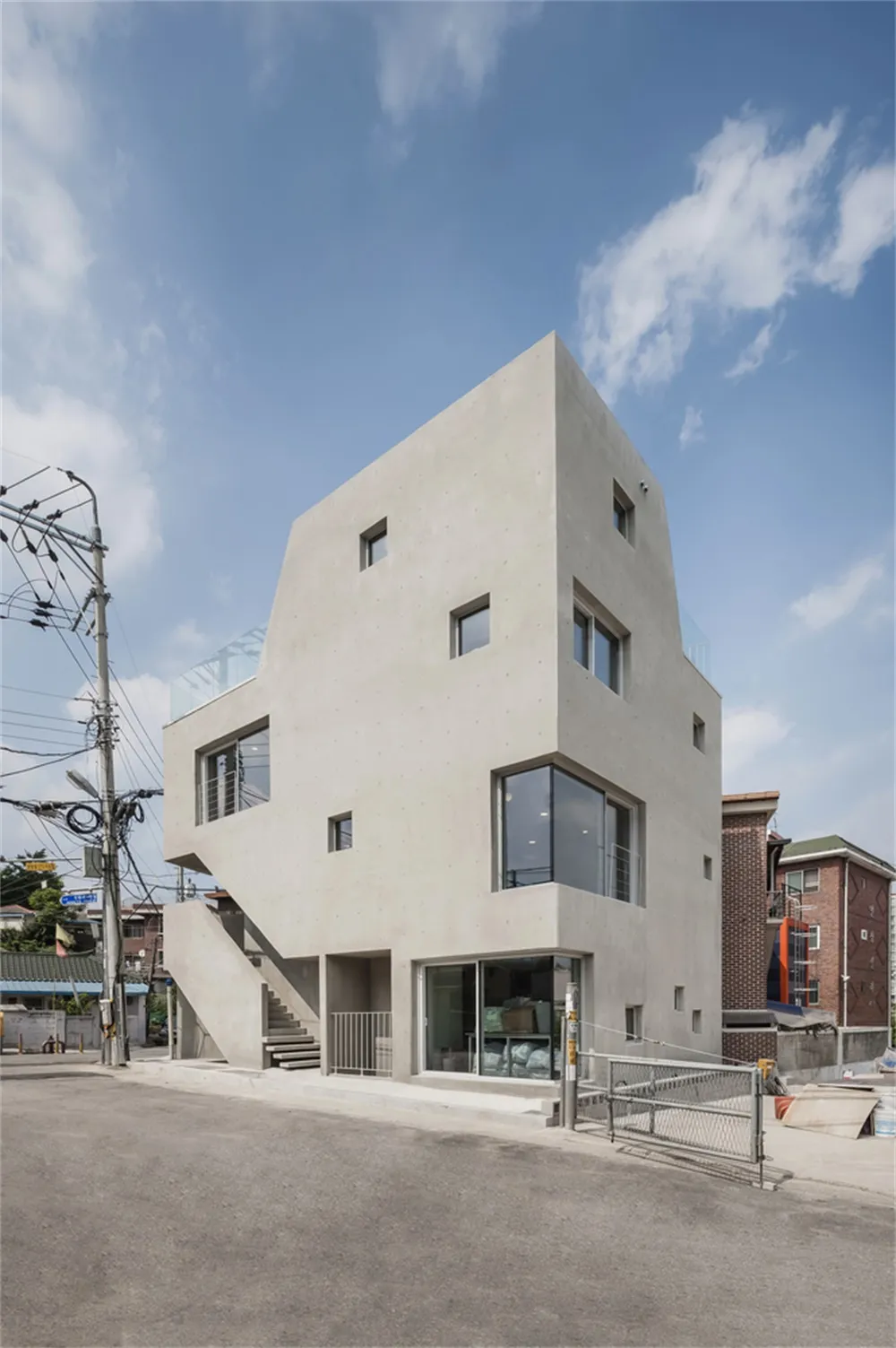 Modern building with smooth concrete exterior and large glass windows.