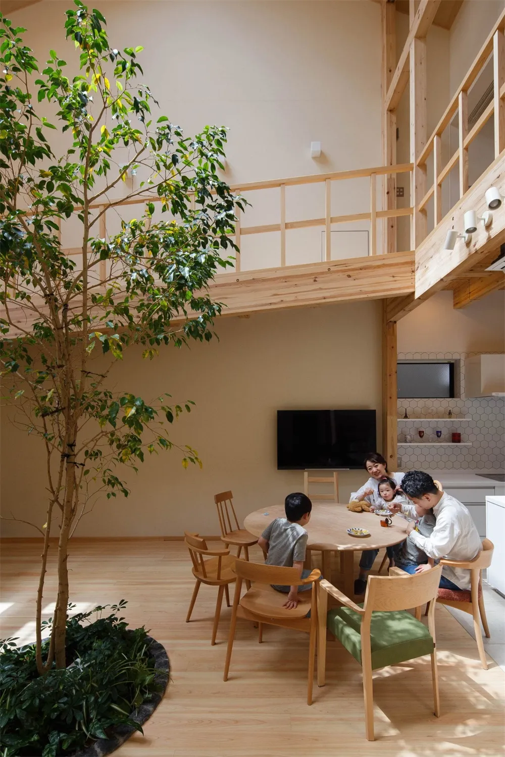 現代餐廳內擺放木質家具,並以一棵活樹作為餐桌中心裝飾。