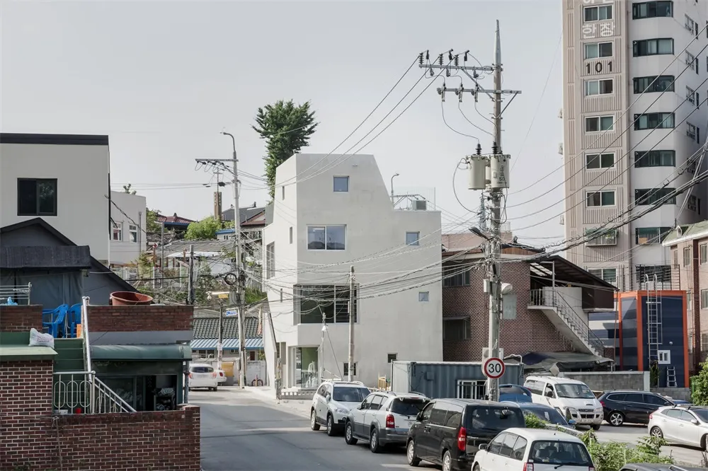 A photo of a modern urban architectural space with buildings, cars, and electrical wires.