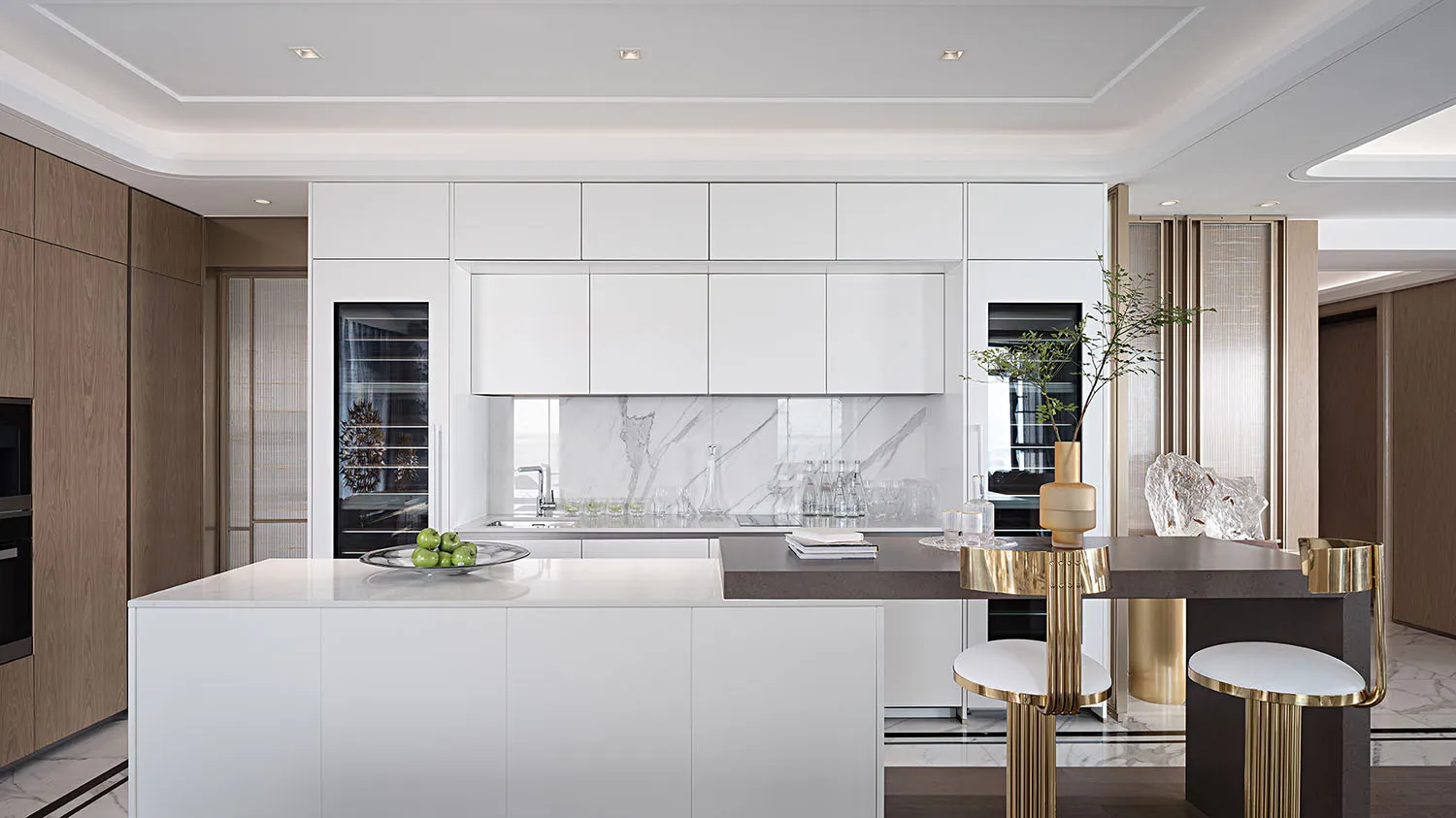 Modern kitchen interior with marble countertops and white cabinets.