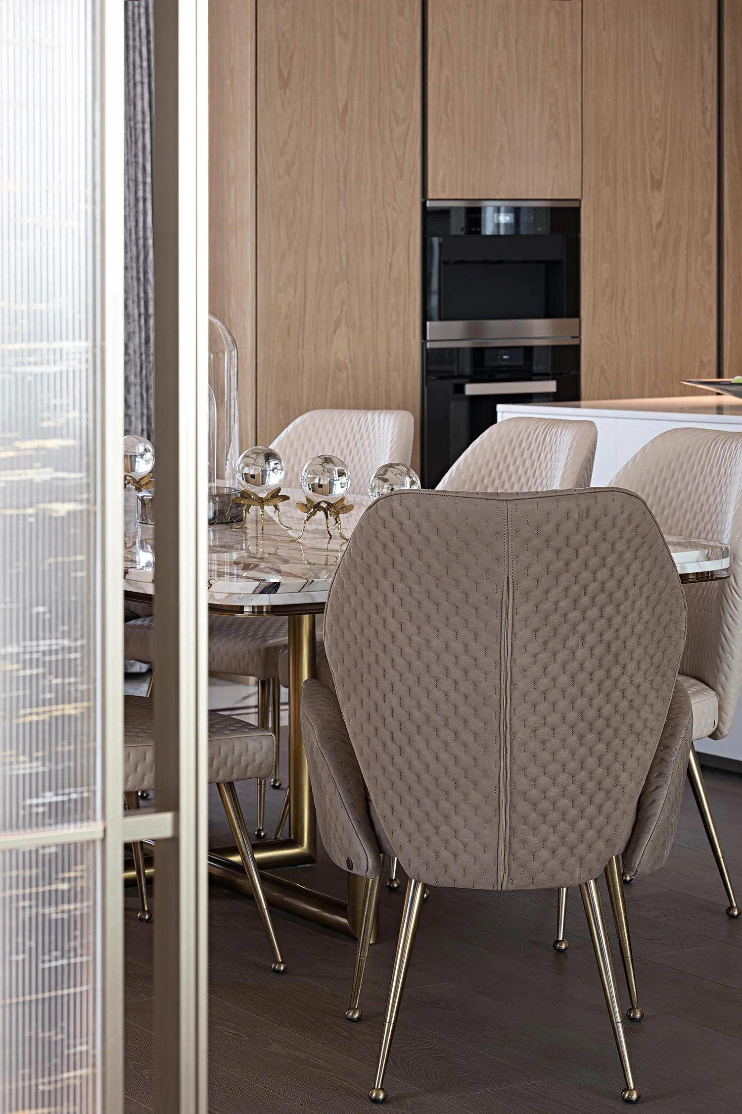 Modern marble dining room with elegant chairs and table centerpiece.