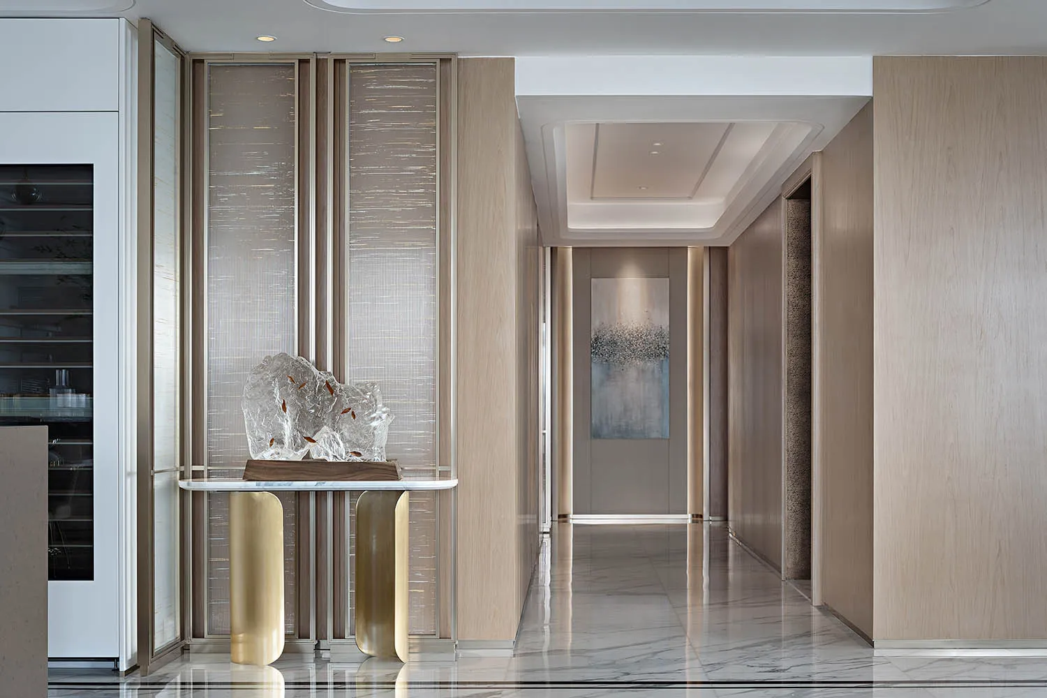 A modern entrance hall with marble flooring and walls, featuring a contemporary sculpture.