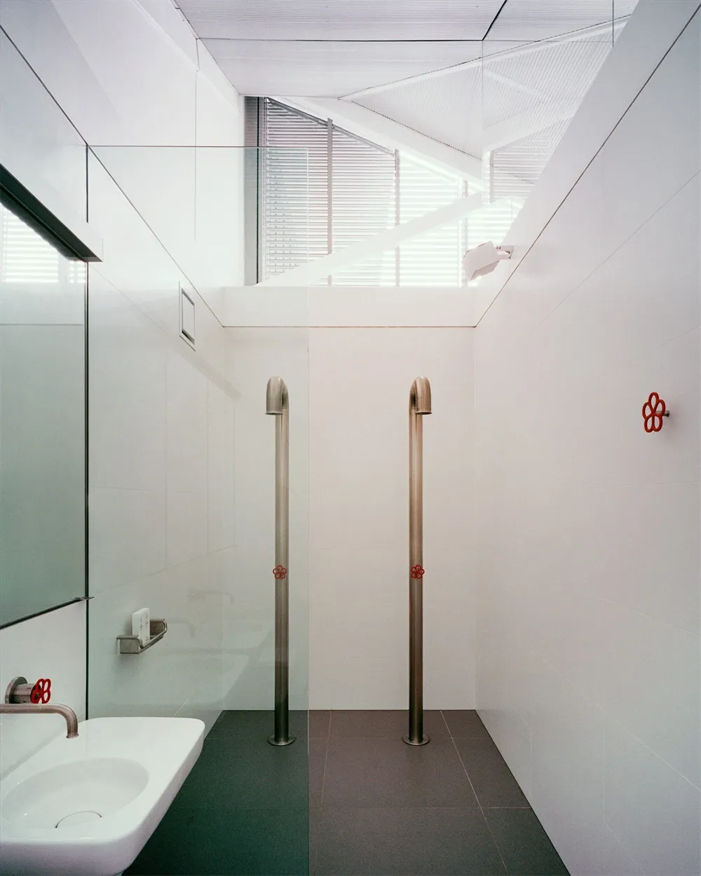A modern bathroom with glass walls and a sink.