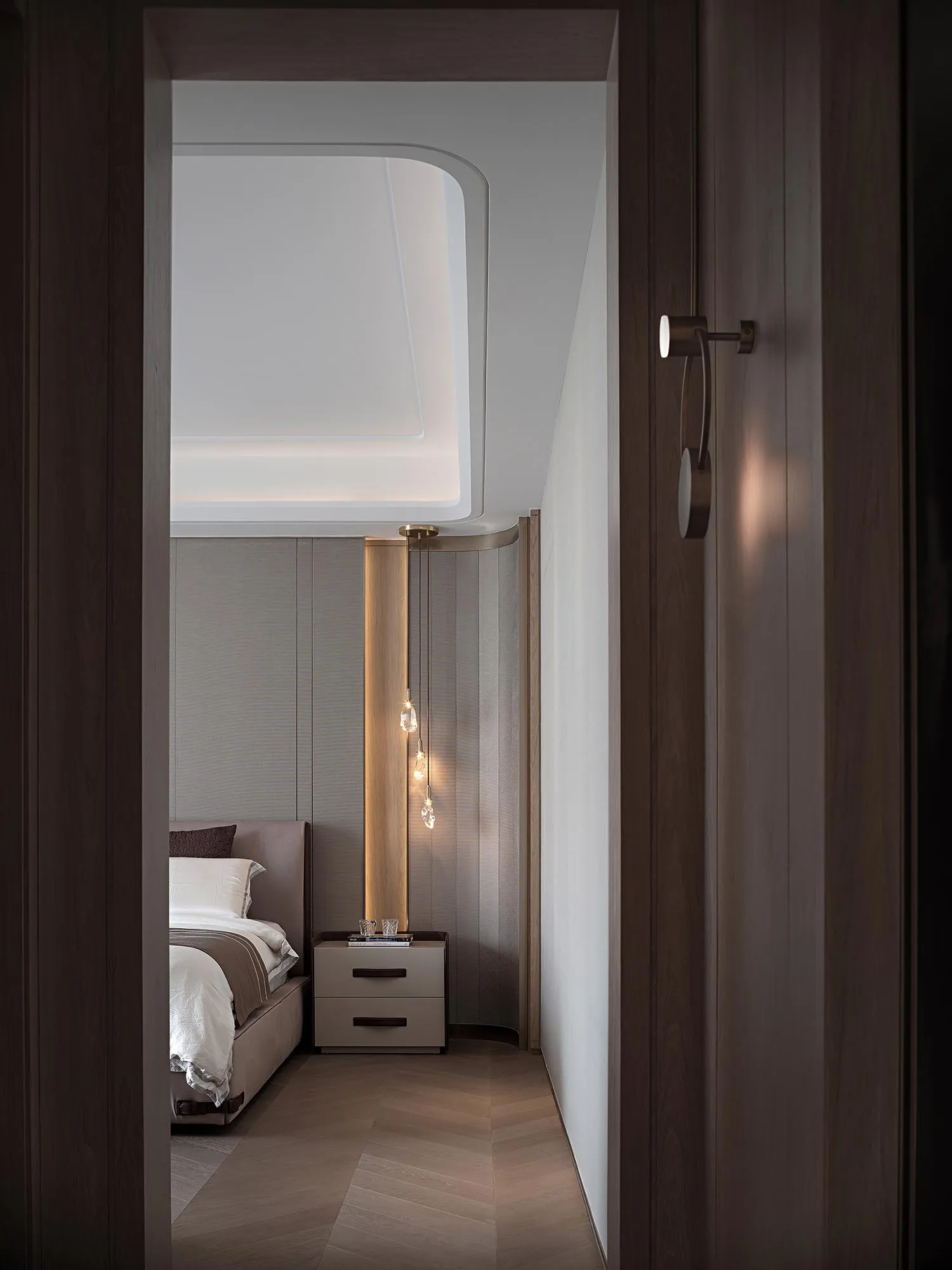 Modern bedroom with wood paneling and a hanging chandelier.
