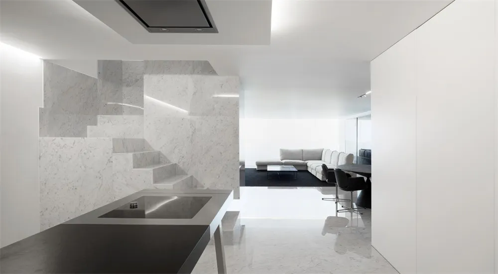 A modern living room with marble walls and a black table.