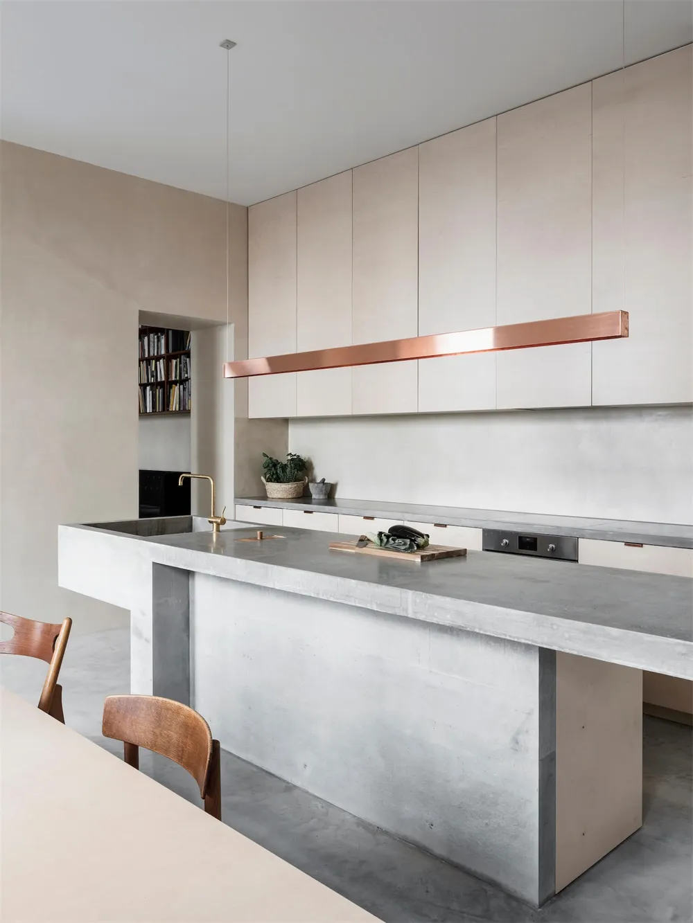 Modern kitchen with concrete countertops and minimalist design elements.