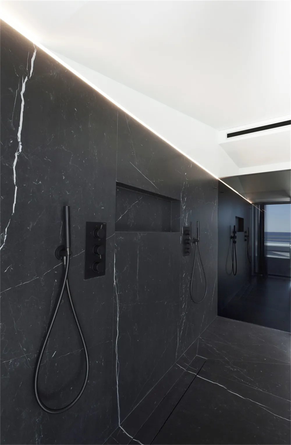 Modern marble bathroom with sleek black fixtures and minimalistic design elements.