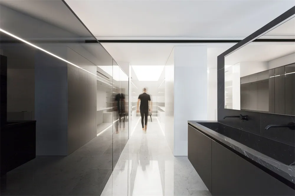 A modern bathroom with black marble finishes and sleek, minimalist design.