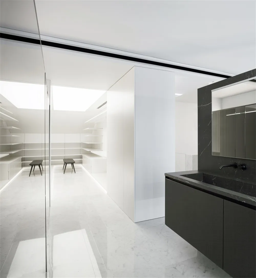 Modern minimalist bathroom with marble flooring and black accents.