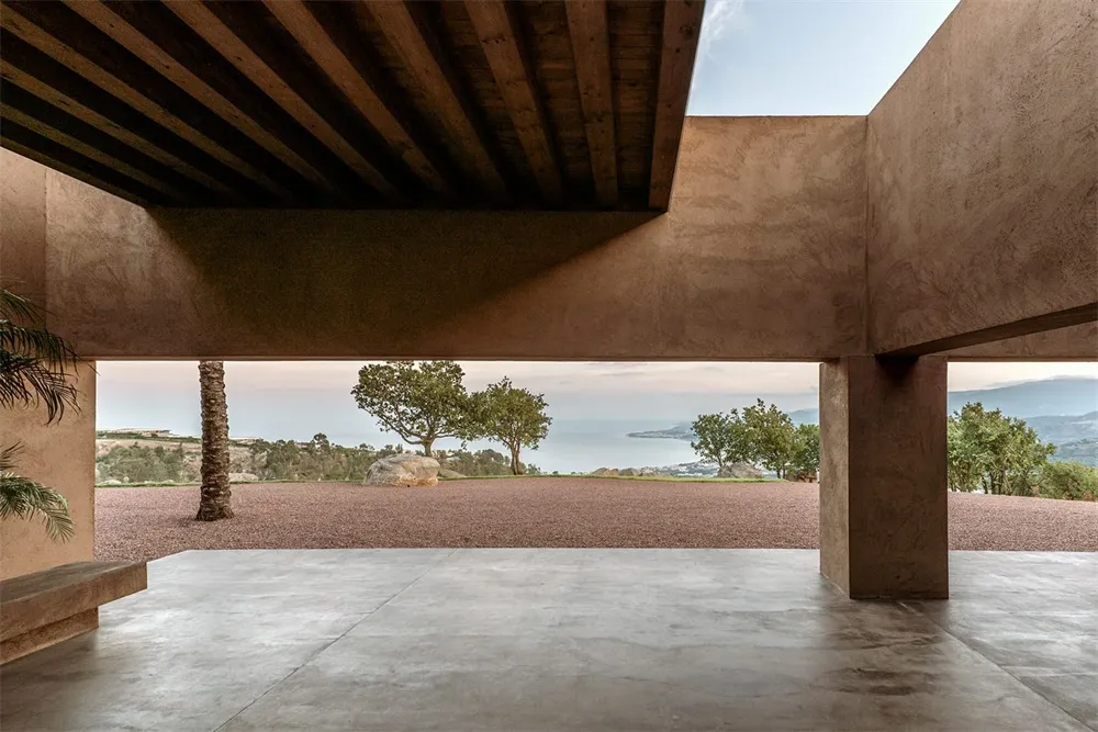 An open, minimalist patio with concrete flooring and a clear view of the natural surroundings.