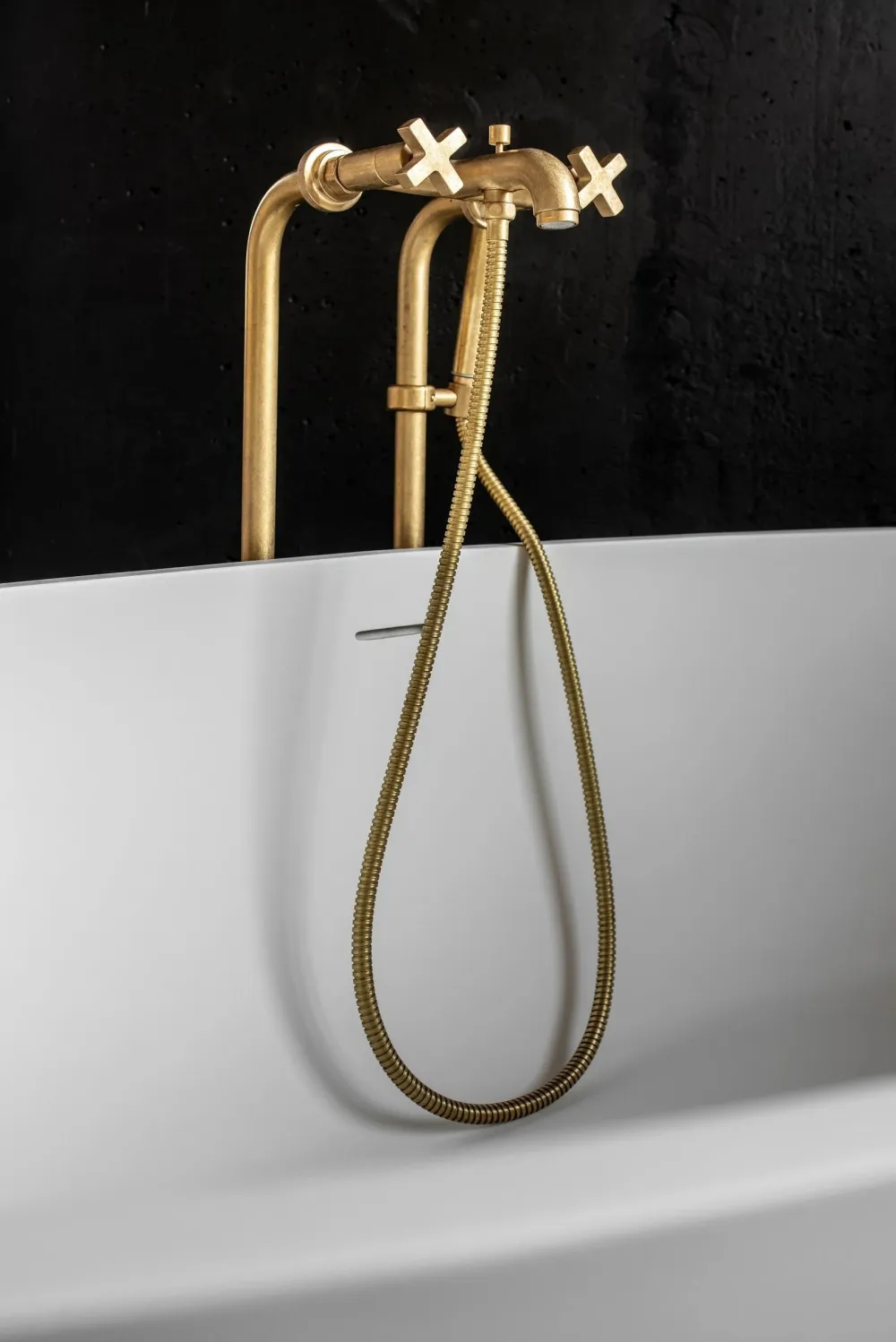 A minimalist bathroom with a metallic faucet and white tub.