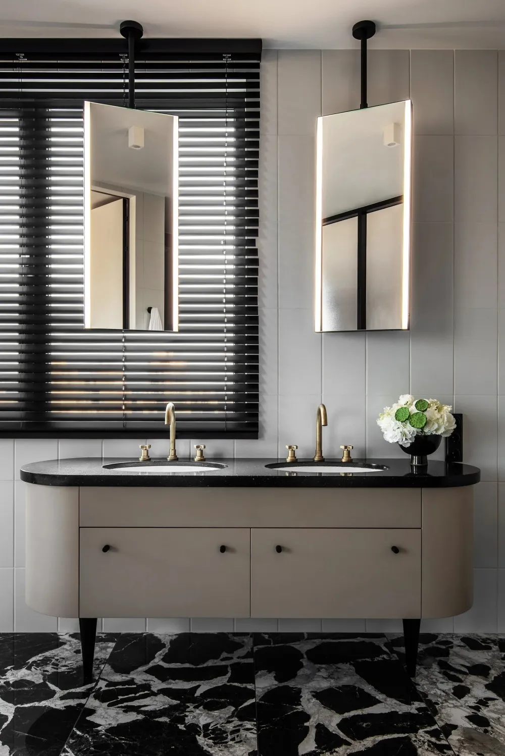 Modern bathroom featuring a double vanity with a marble countertop and black marble flooring.
