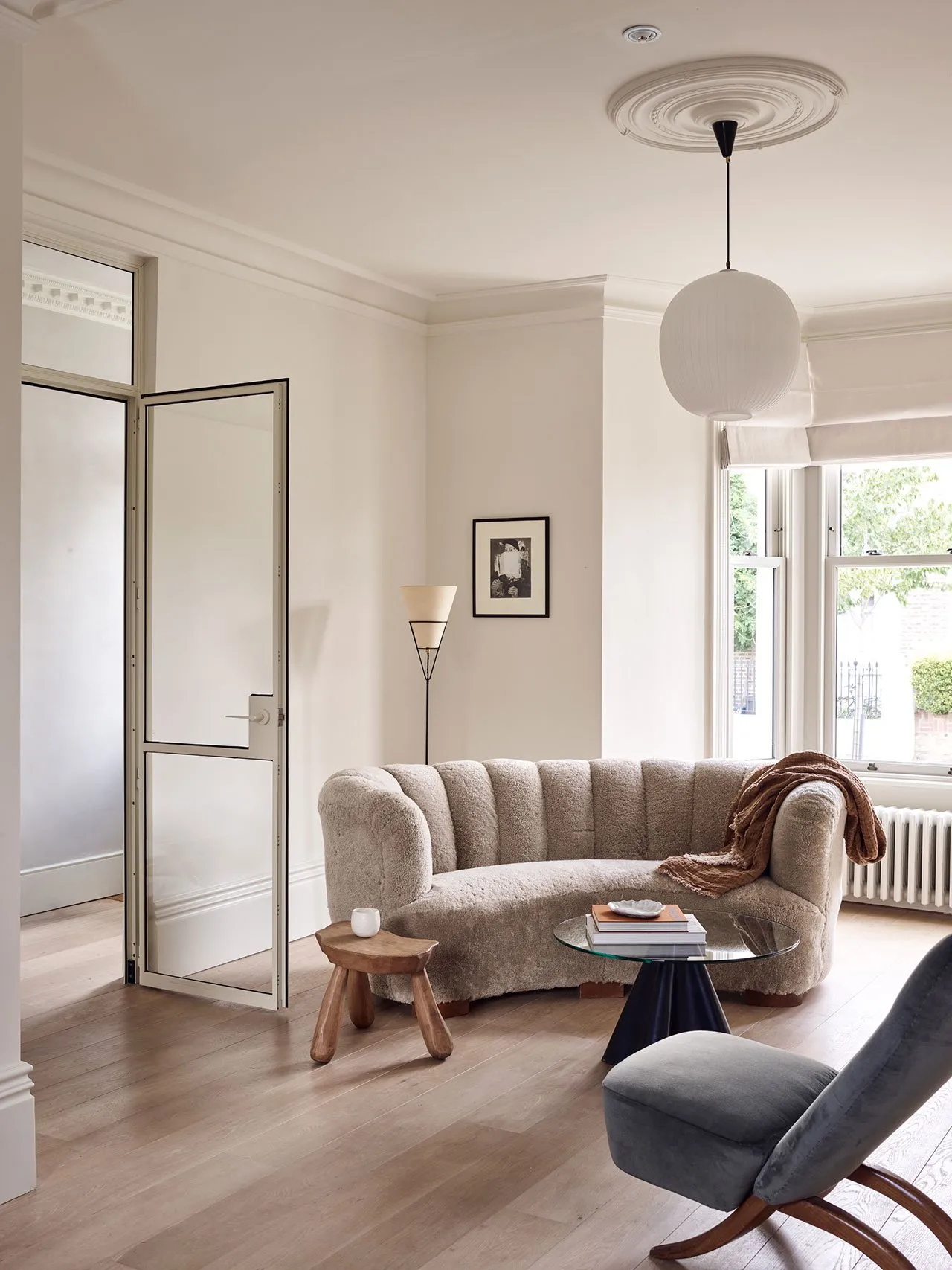 Modern, curved sofa with neutral fabric in a living room setting.