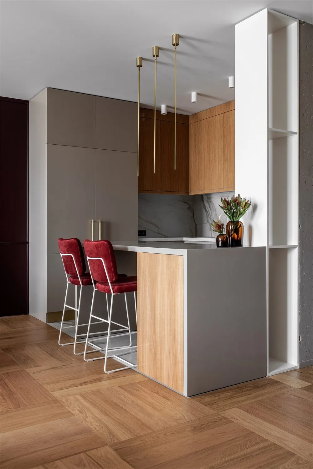 Modern kitchen interior with marble countertops, concrete walls, and wooden cabinets.