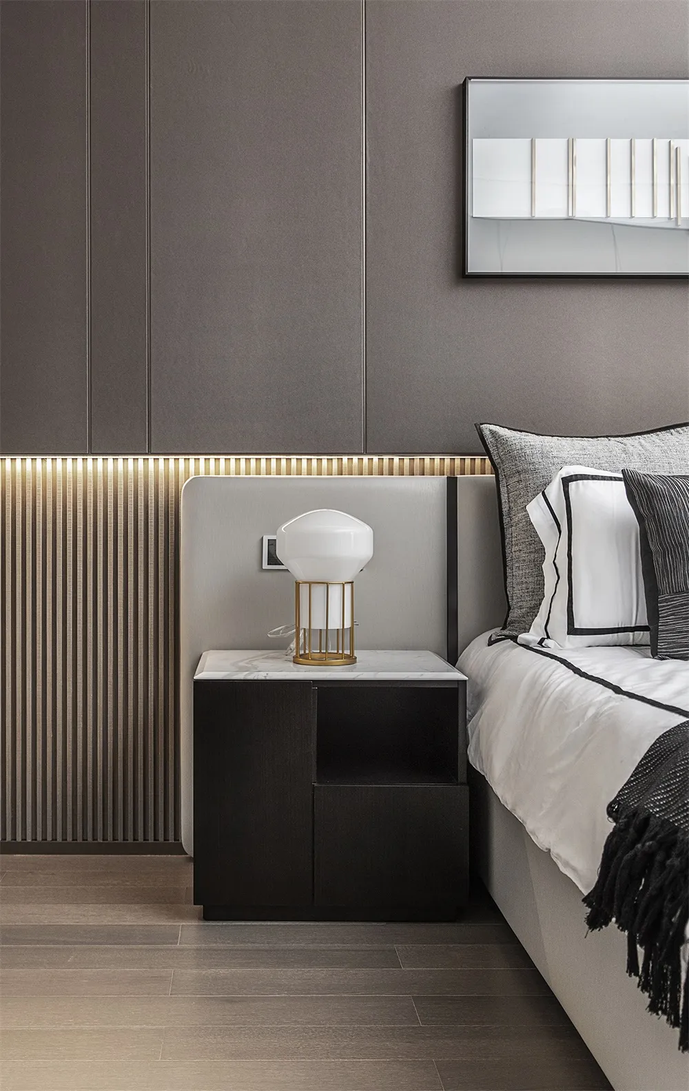 Modern minimalist bedroom featuring a marble top nightstand, wooden floor, and metal accents