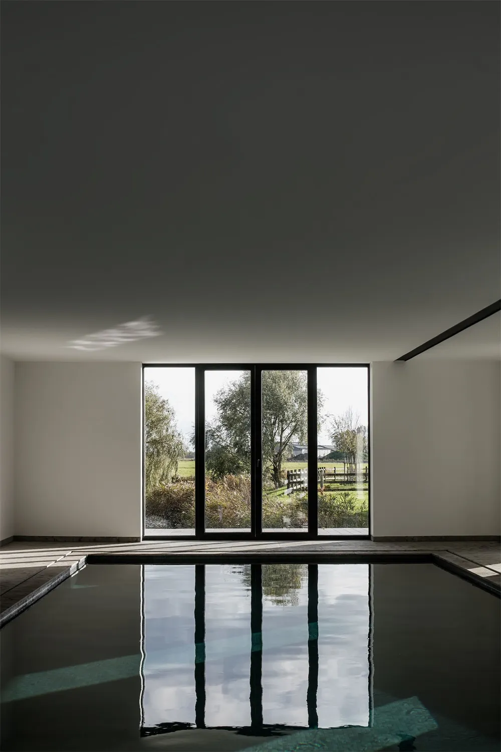 Modern glass poolside with natural landscape view