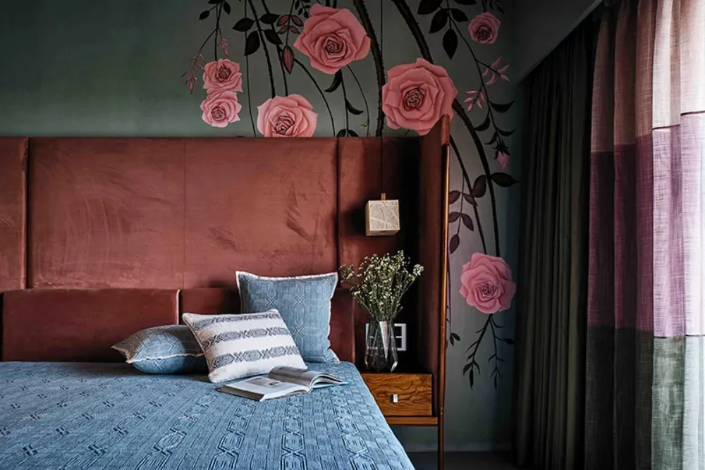 Modern bedroom featuring floral wallpaper and soft textiles, with a large bed and decorative pillows.