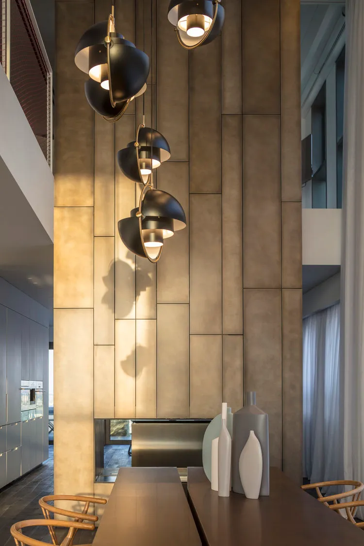 Modern dining room with metallic textured wall and hanging light fixtures