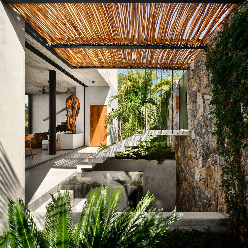 Concrete, bamboo, and stone residential entryway with a modern design