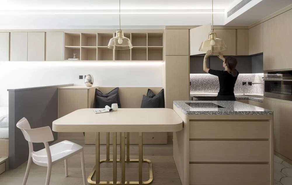Modern minimalist kitchen featuring wooden cabinets, marble countertop, and metal accents.