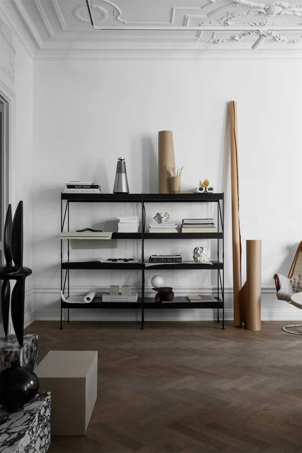 A modern interior featuring black metal shelves with books and decorative items.