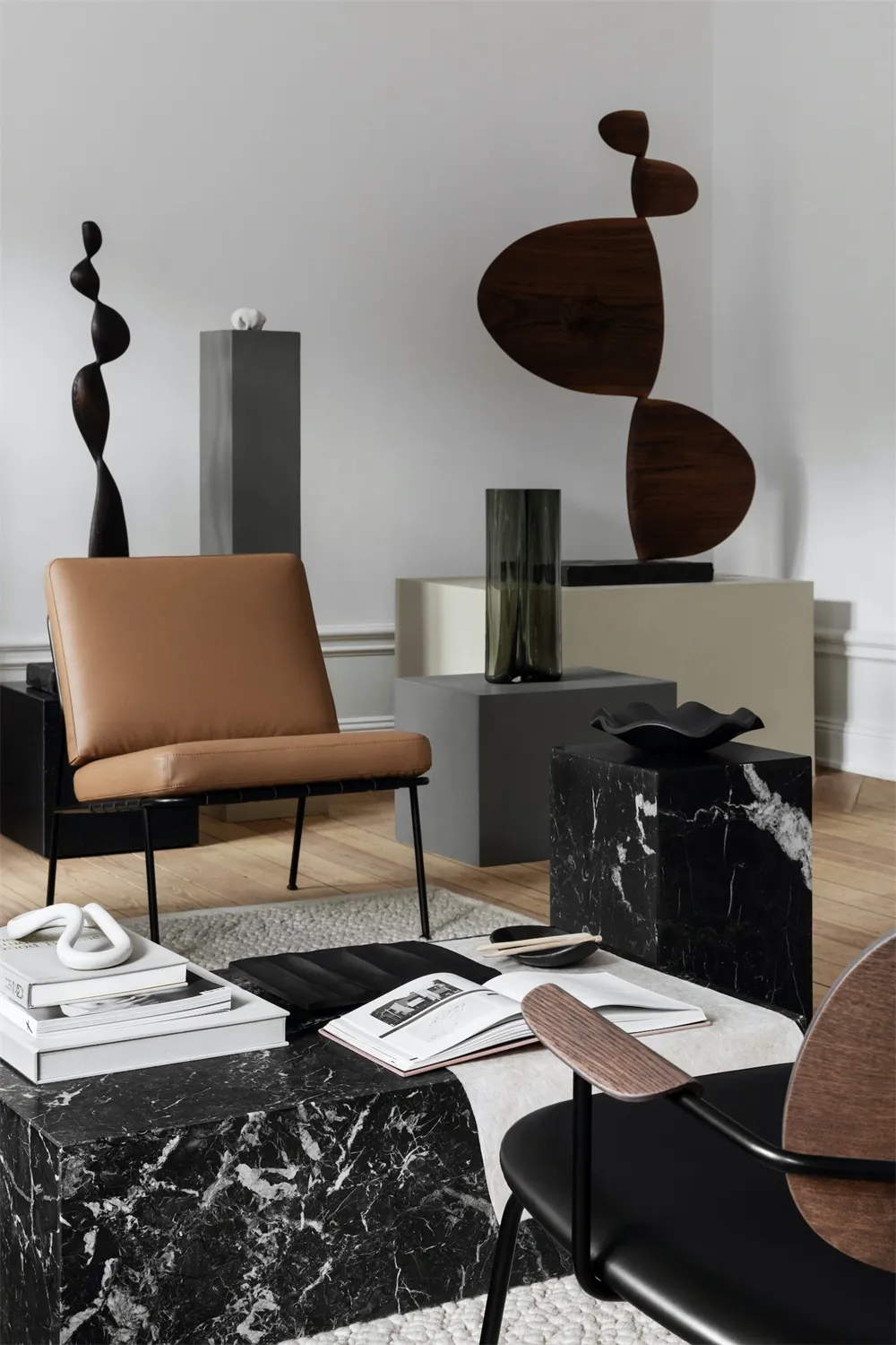 Modern, minimalist living room featuring polished marble furniture and sculptures.