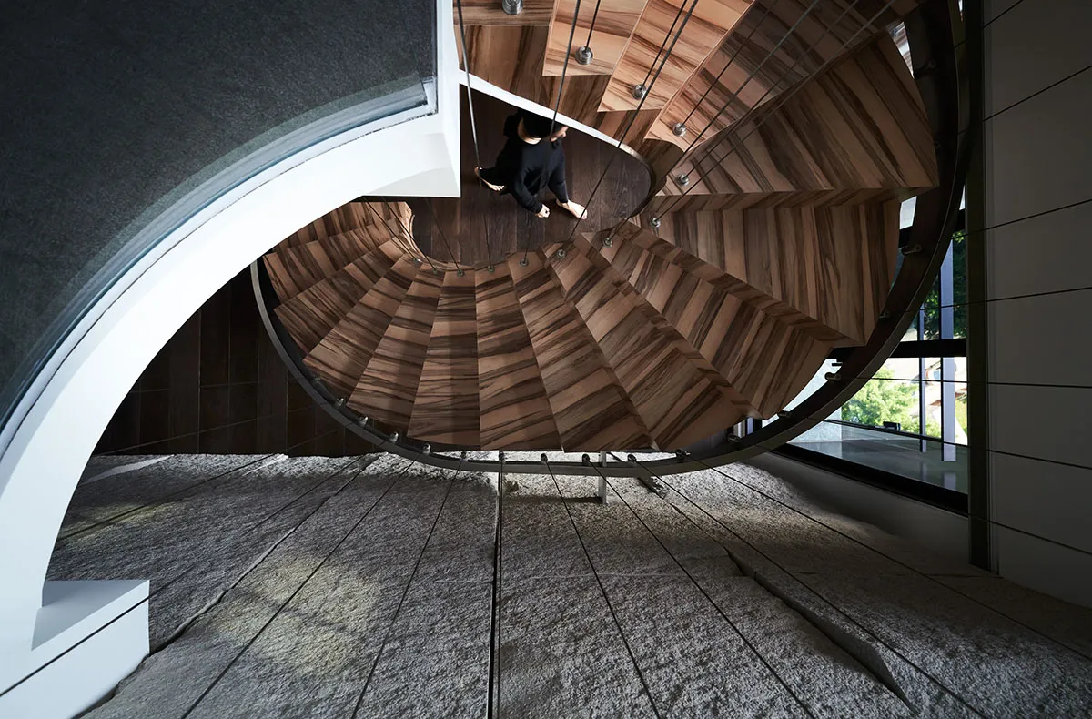 A modern, wooden staircase with a spiral design.