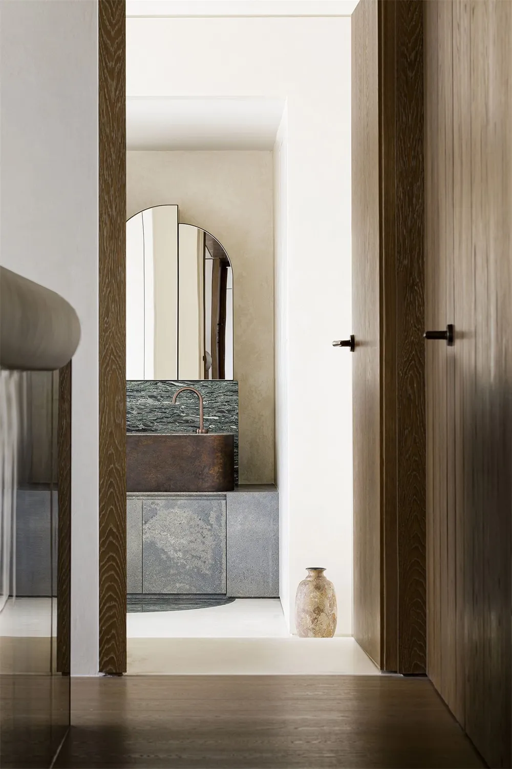 A minimalist bathroom featuring a concrete countertop and brass fixtures, showcasing modern design elements.