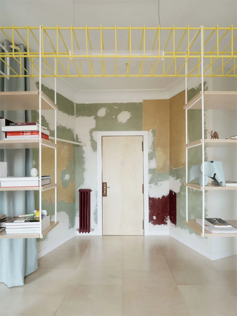 Minimalist room featuring wooden furniture, rope shelves, and metal accents.