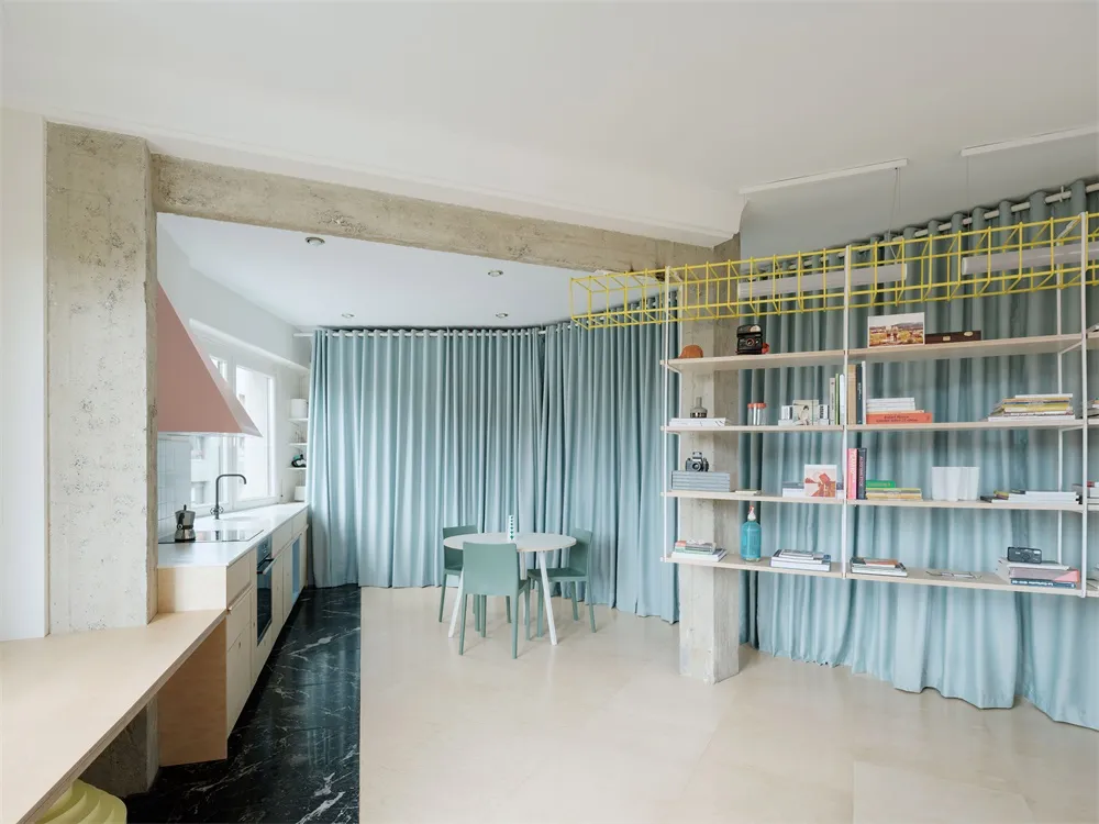 A minimalist residential living space featuring concrete, glass, and light wood materials.