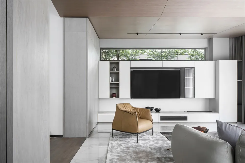 A modern living room with white concrete walls, a marble floor, and minimalist furniture.