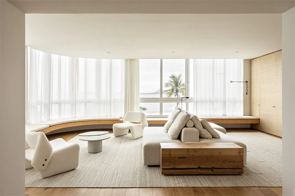 Modern living room with natural fiber rug, concrete coffee table, and timber furniture.