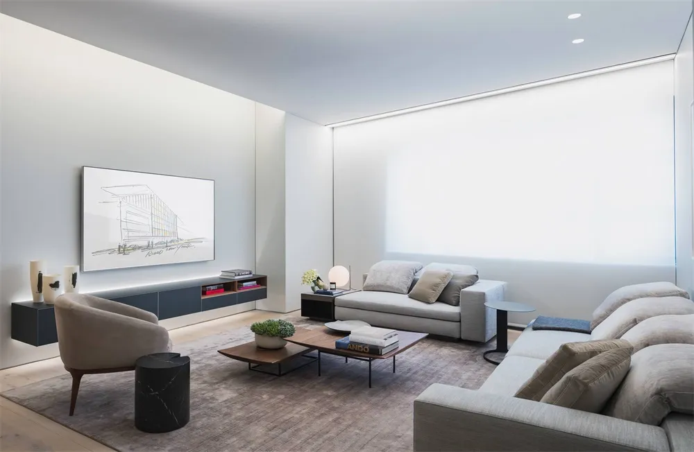 Contemporary modern minimalist living room setting featuring light-colored furniture, grey sofa, and light brown armchair wit