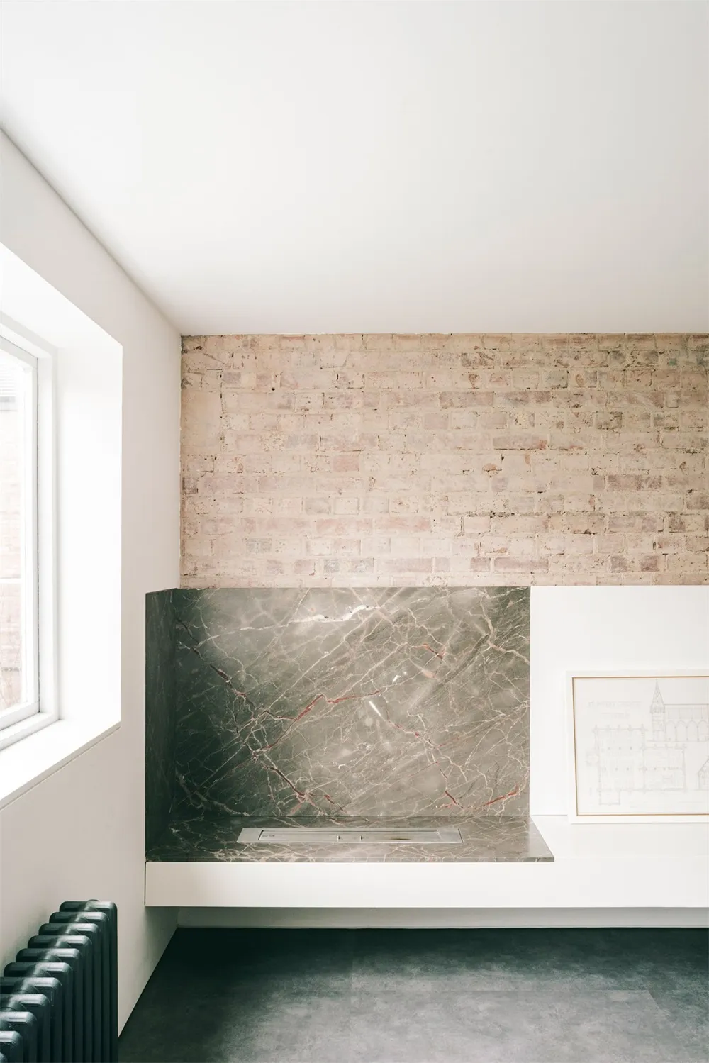 A modern industrial kitchen featuring exposed brick walls and a marble backsplash.