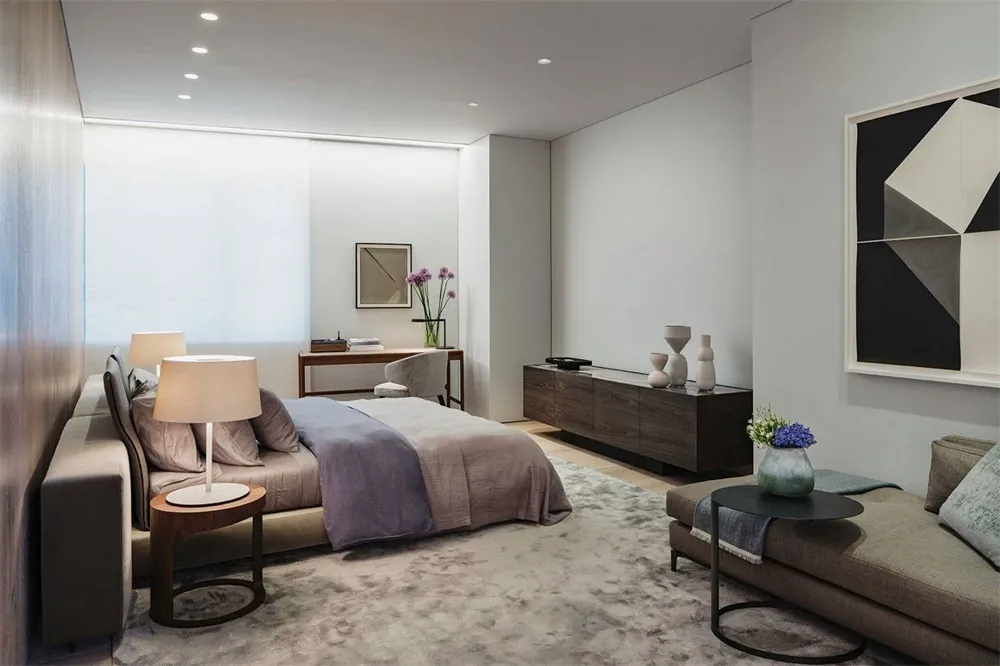 Contemporary bedroom featuring a clean, simple design with a wooden bed frame and a plush rug.