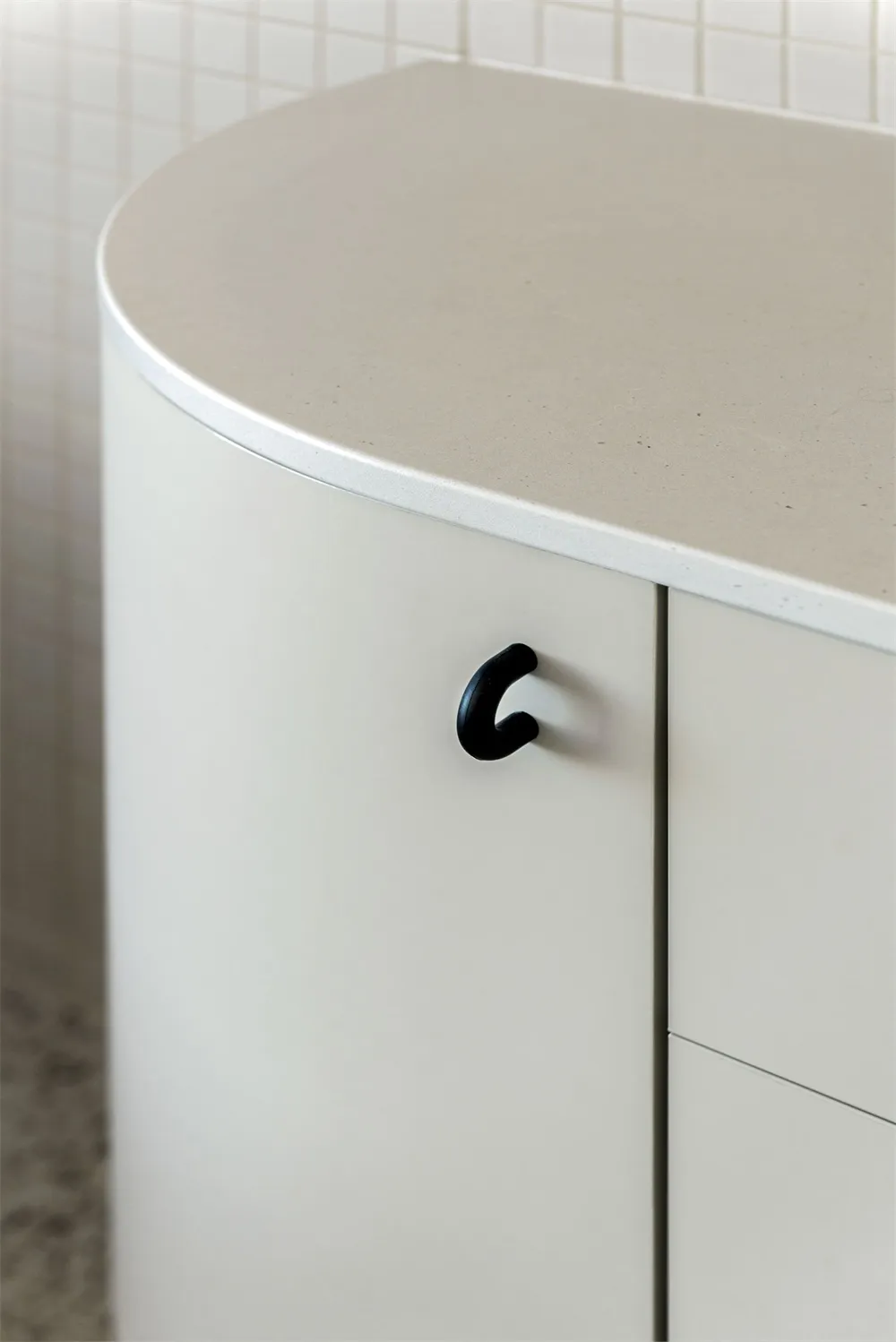 A minimalist interior design featuring a white counter top and cabinets made of concrete.