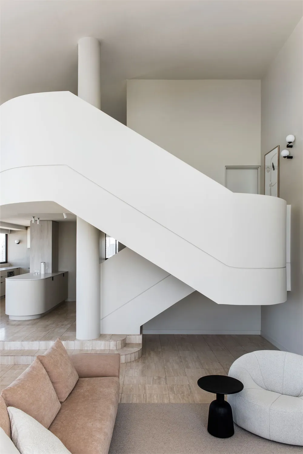 A modern living room with a minimalist aesthetic, featuring a staircase made of white concrete.